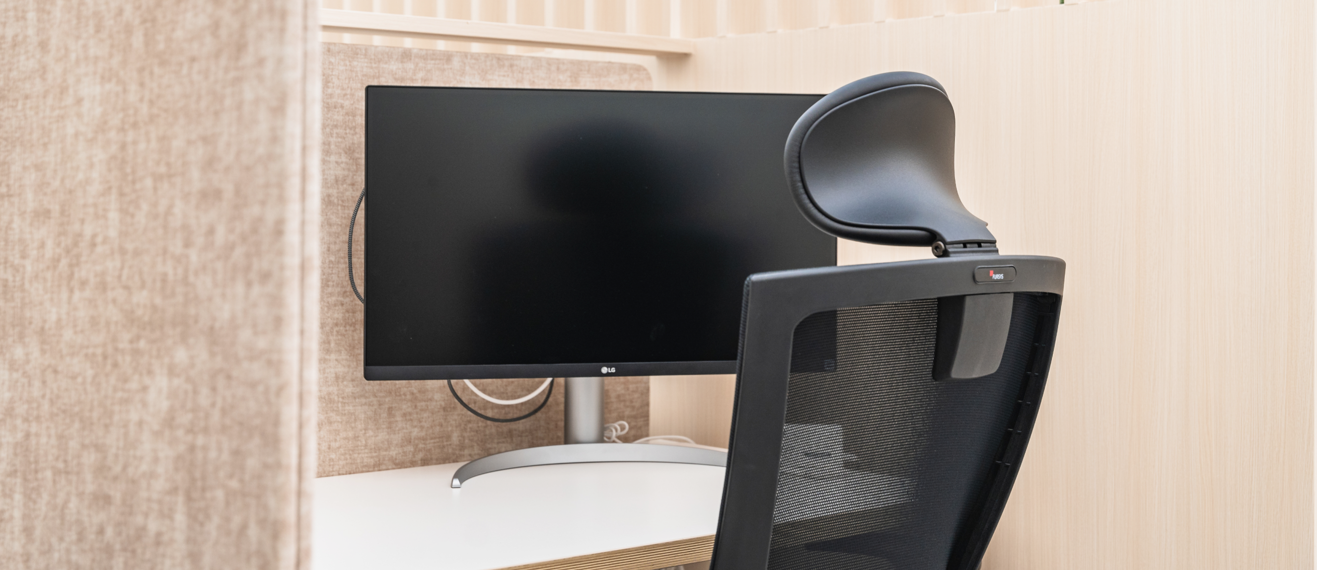 파티션으로 구분된 독립적인 집중 업무 공간과 와이드 모니터, 사무용 의자